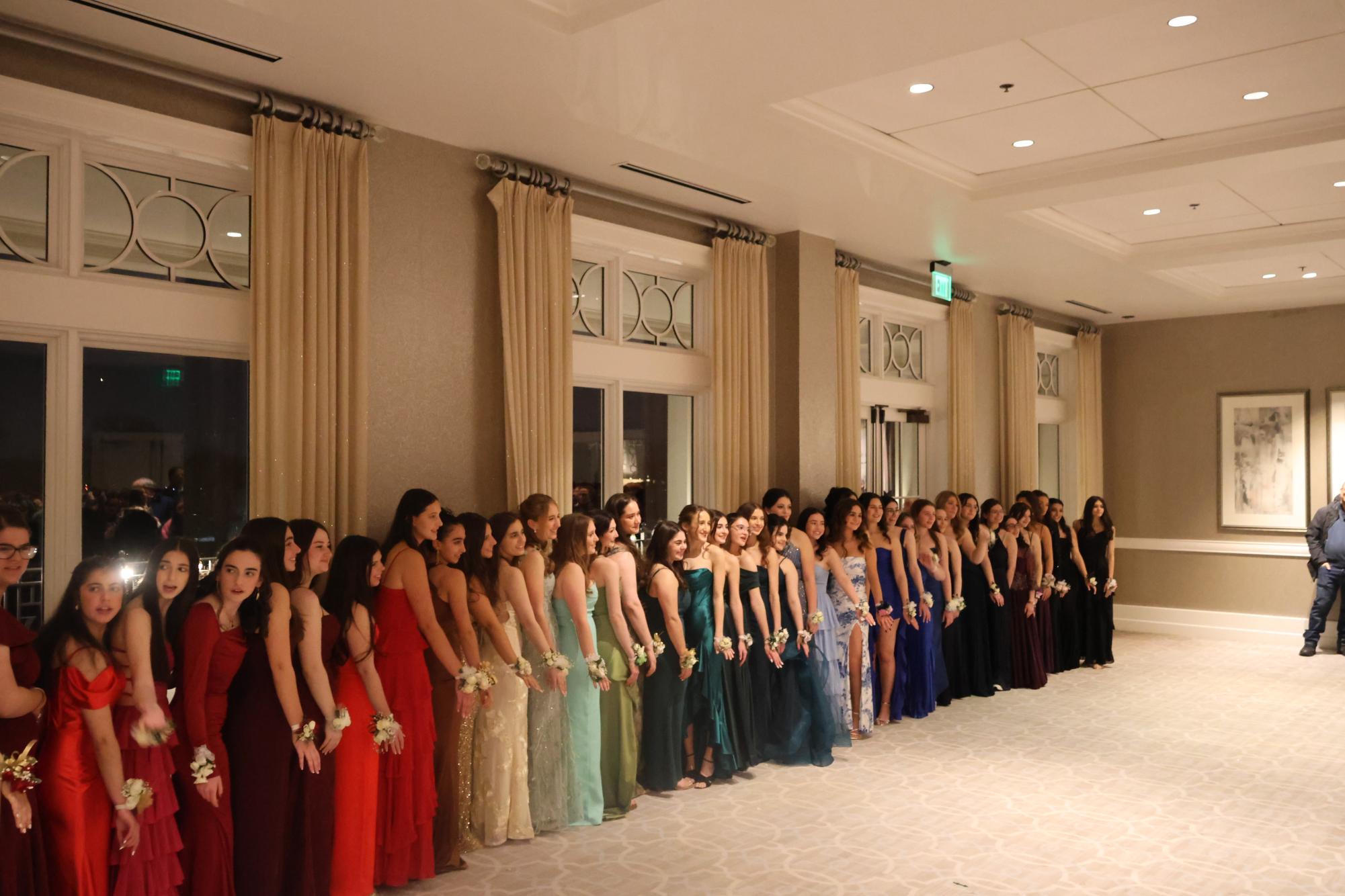 Girls lined up in order of their dress color at pre-prom photos.