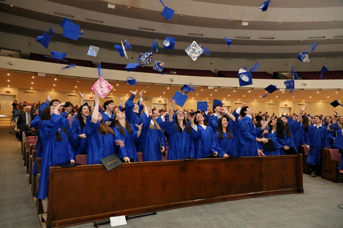 Seniors throw their caps in the air at the end of the graduation ceremony. Many seniors decorated and personalized their caps before the ceremony. 