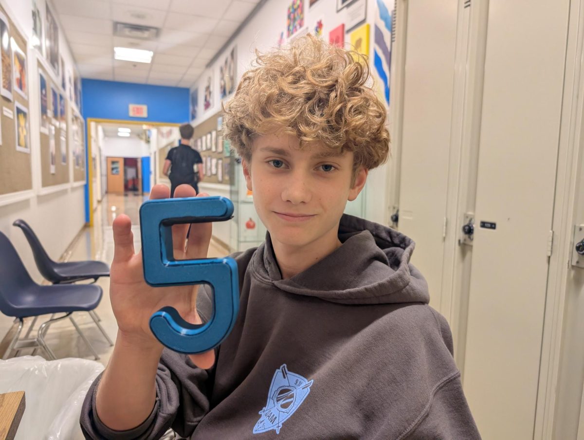 Adam Nesher holds up a sample of his new backpack holder