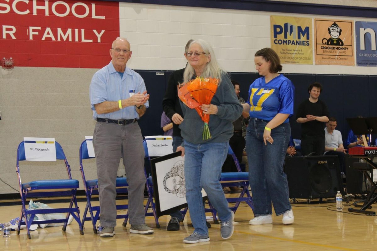 Honoree Sue Zuckerman, Feder Family Director of Upper School Educational Support Services, walks back to her seat after receiving flowers and a drawing given to her by her former student Jordan Levin (‘85). She is being honored for her more than 40 years of work at JDS and for inspiring students through her work in founding The Lion's Tale and in Educational Support Services. “It is really a great, great honor, particularly since I shared it with Rachelle Sobel, whom I admire tremendously, and Abbey Frank, who I've known forever and to be part of that makes me feel very good,” Zuckerman said.
