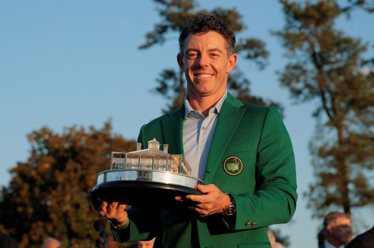 Golf - The Masters - Augusta National Golf Club, Augusta, Georgia, U.S. - April 12, 2026 Northern Ireland's Rory McIlroy celebrates with his green jacket and the trophy after winning The Masters REUTERS/Brian Snyder