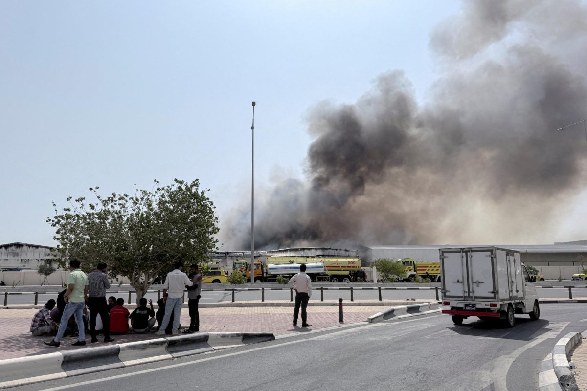 People gather as smoke rises at the Industrial Area after reported Iranian missile attacks, following United States and Israel strikes on Iran, in Doha, Qatar, March 1, 2026. 
