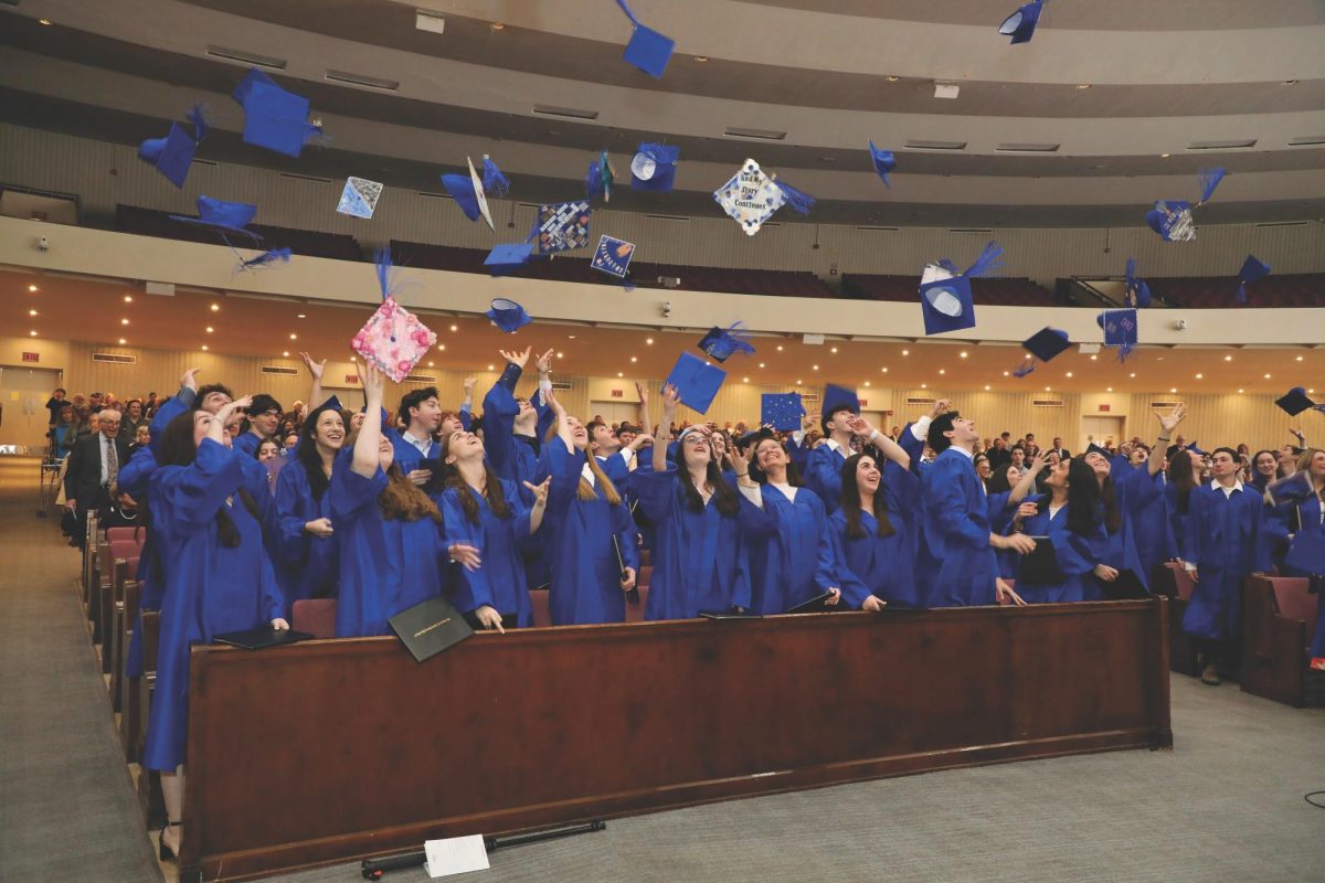 Seniors throw their caps up at their February graduation ceremony.
