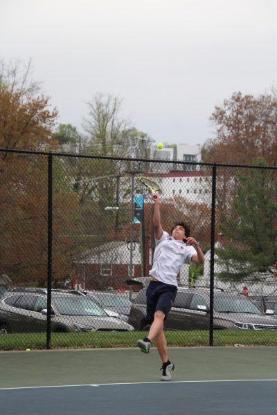 Junior Ryan Klepper tosses the tennis ball during a match.