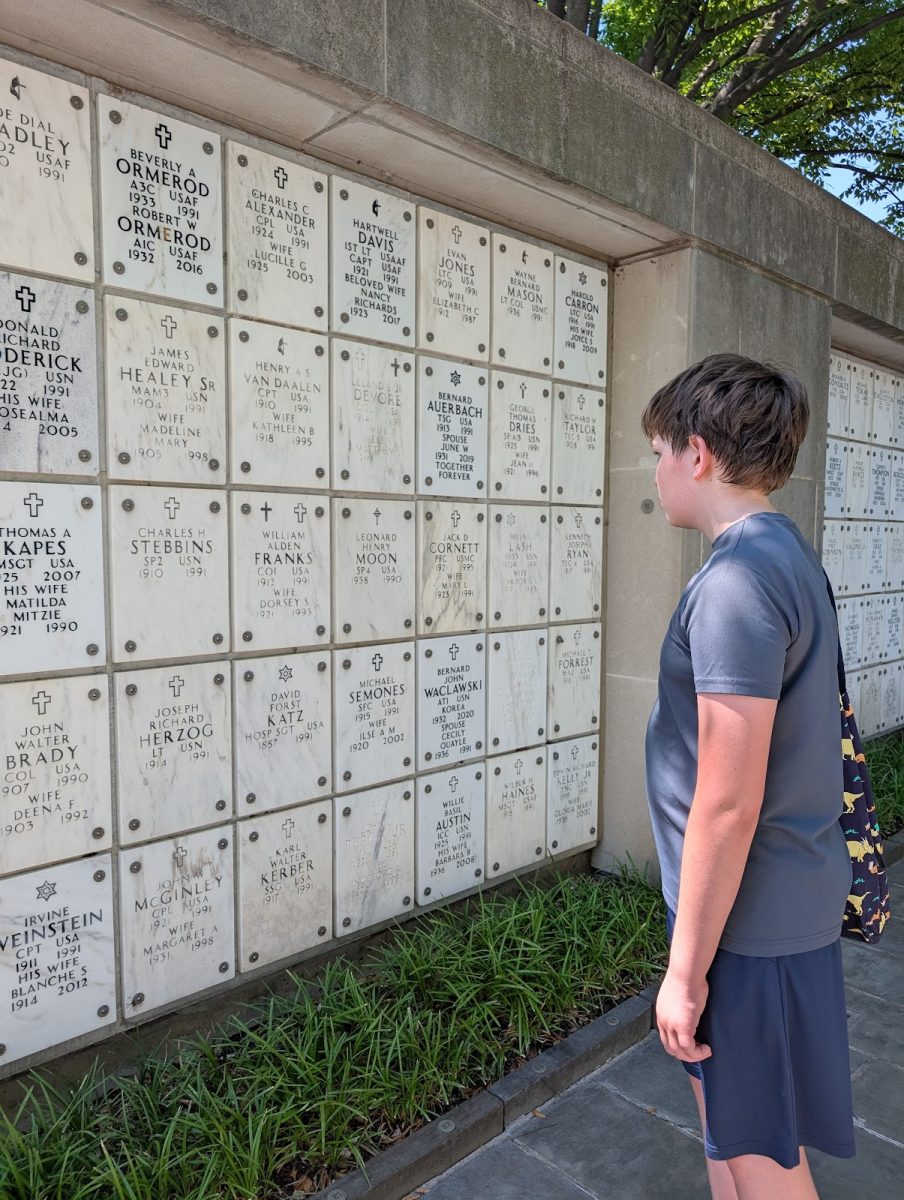 Seventh-grade student Jonah Rand reads the names of deceased soldiers in Arlington National Cemetery's columbarium.