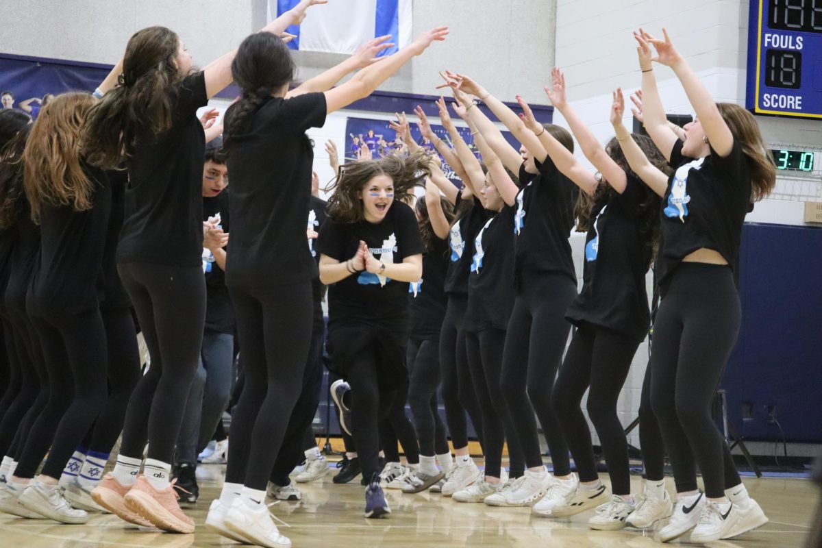 Junior Claire Elbaum dances with her grade on the gym floor.